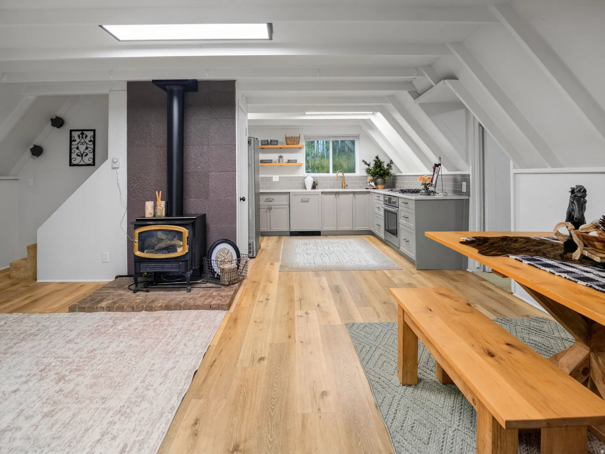 Wood-finish flooring throughout, with a wood-burning stove on a brick hearth