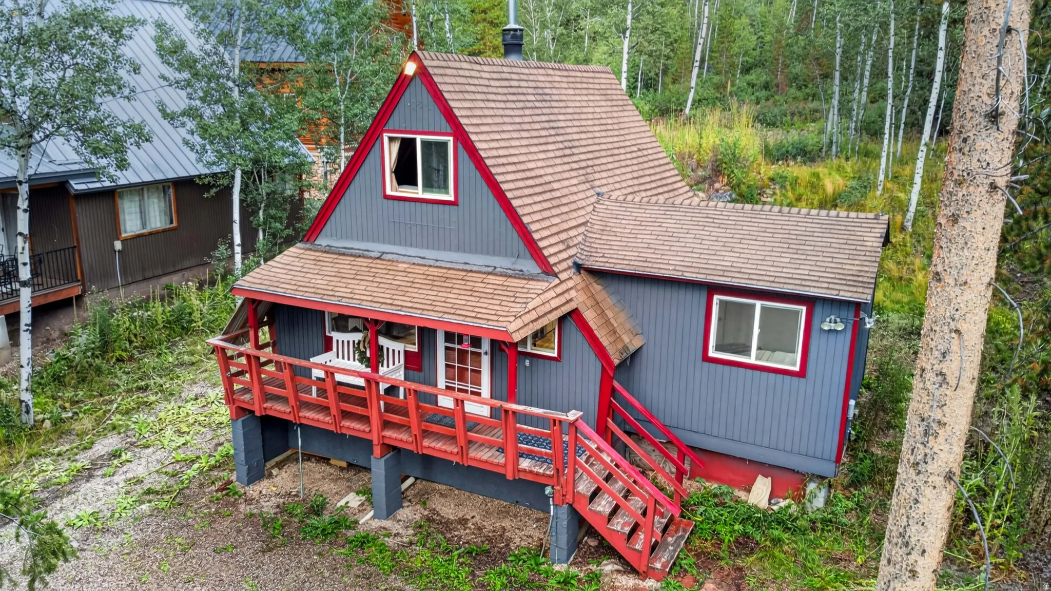 A-frame style residence with gray siding and red trim accents