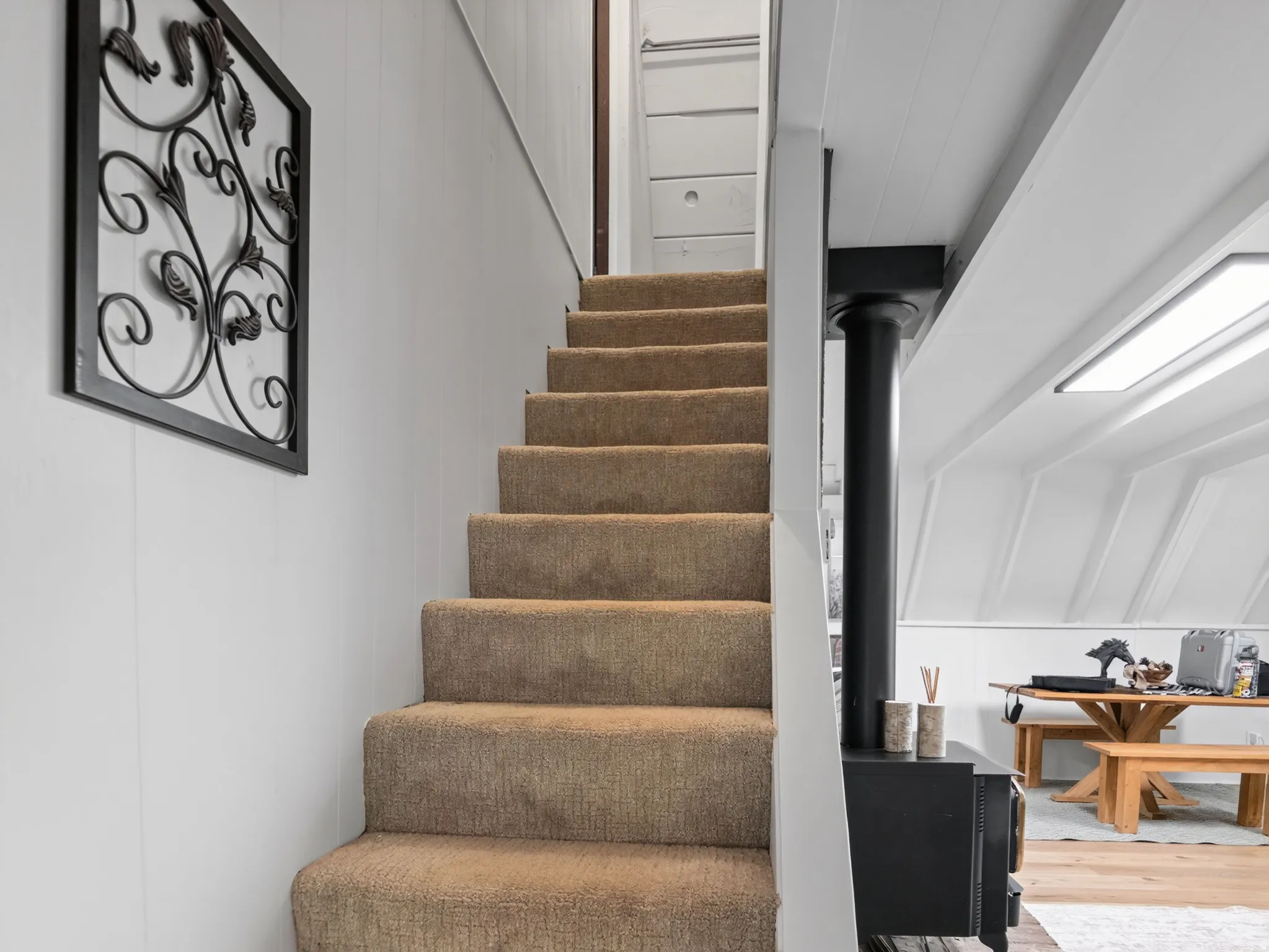 Carpeted staircase with paneled walls, leading to an upper level