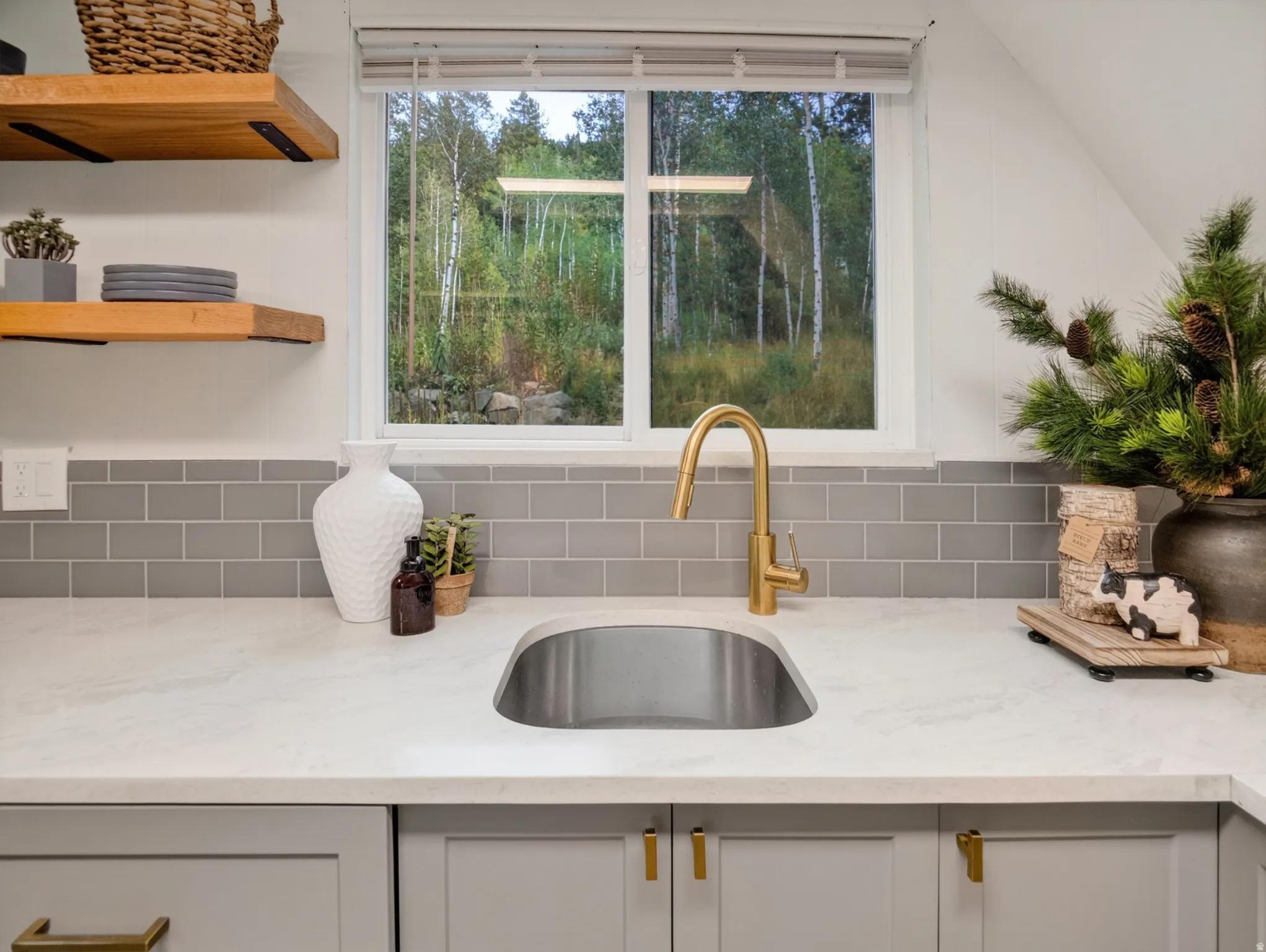 Undermount stainless steel sink with a gold-finish gooseneck faucet