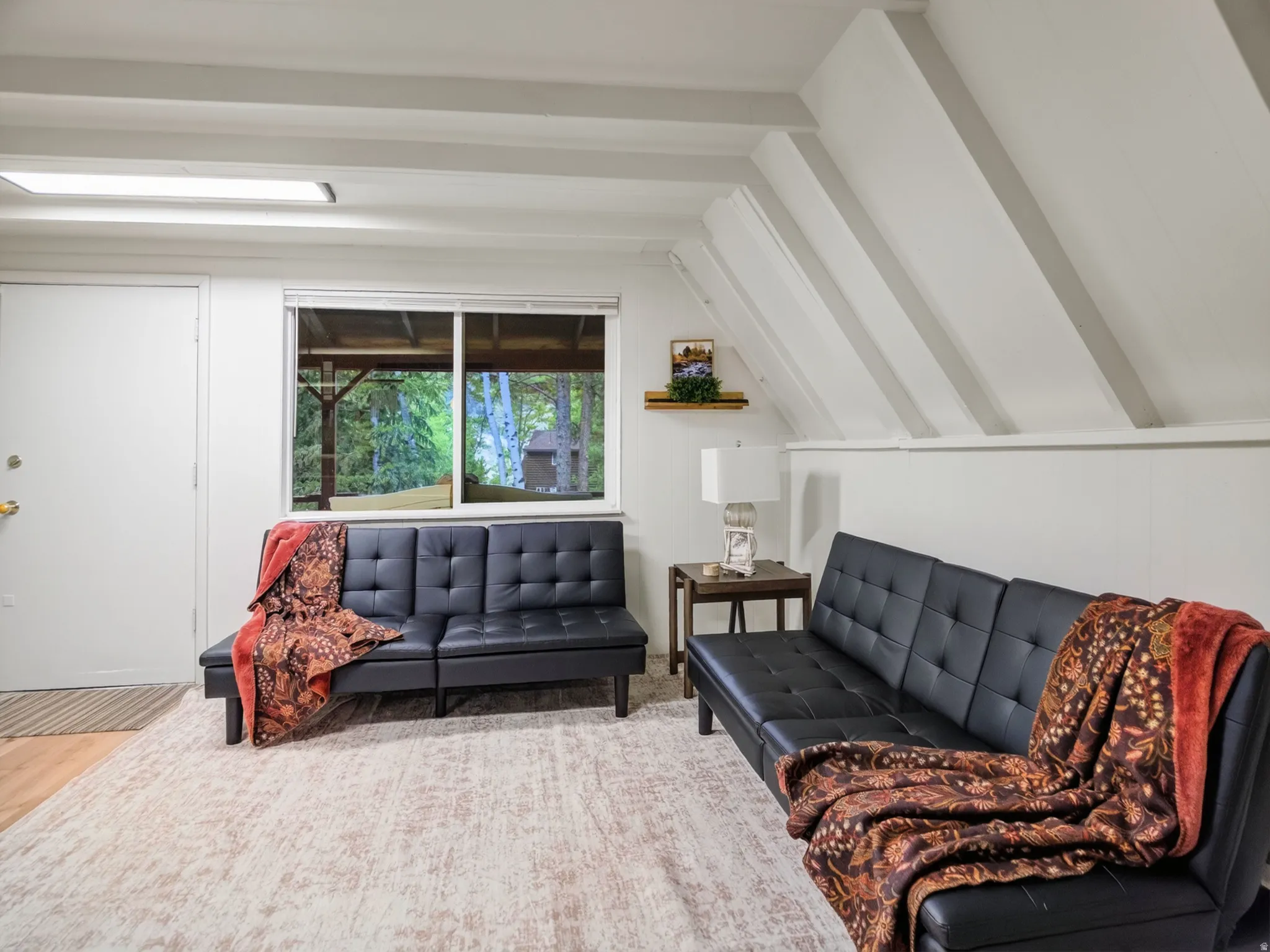 Exposed ceiling beams, recessed lighting, and a large window providing natural light