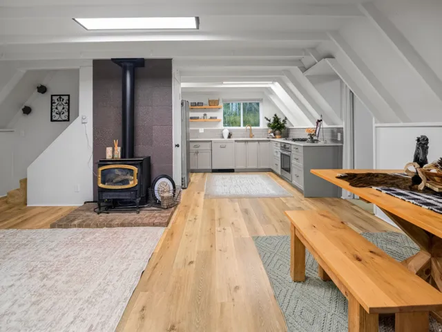 Wood-finish flooring throughout, with a wood-burning stove on a brick hearth