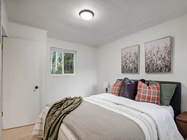 White paneled walls, recessed window, white ceiling with flush-mount lighting, and carpeted flooring