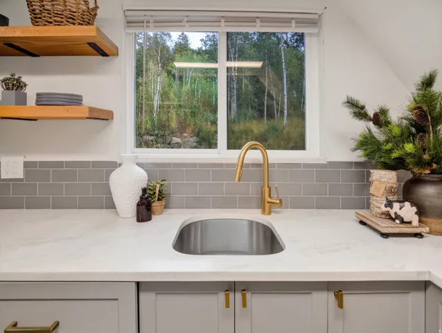 Undermount stainless steel sink with a gold-finish gooseneck faucet
