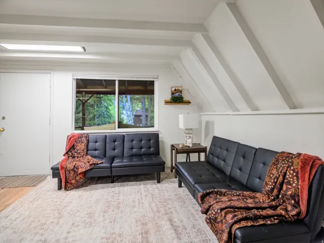 Exposed ceiling beams, recessed lighting, and a large window providing natural light