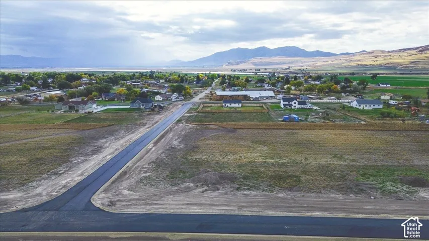 Expansive acreage with paved street access, featuring a horizon backdrop of mountain ranges and open terrain
