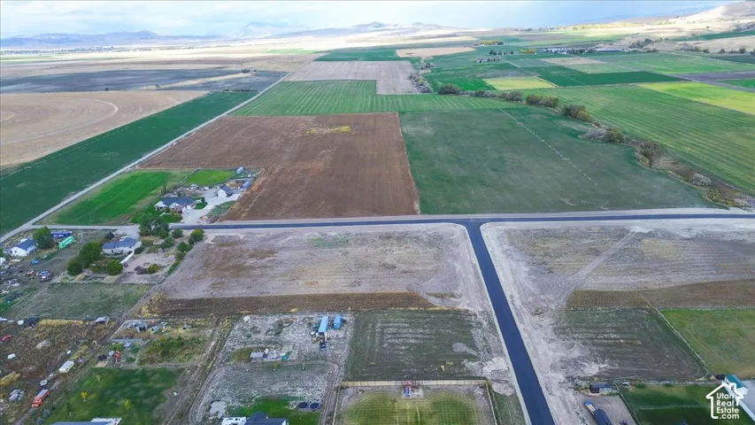 Expansive acreage featuring paved road access, leveled terrain, and mountain horizon backdrops