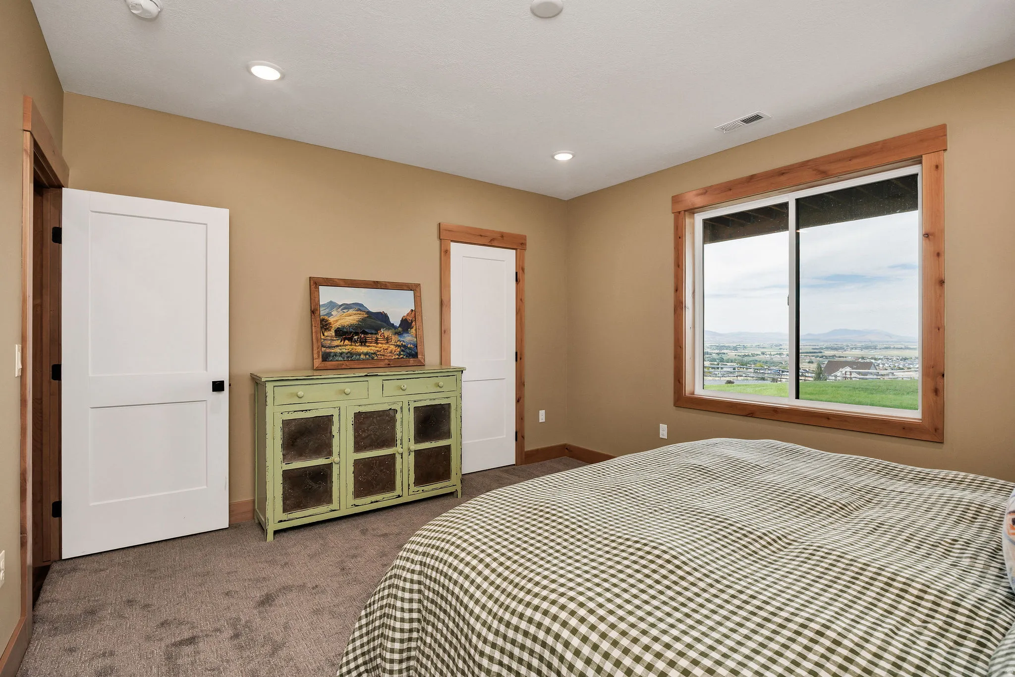 Recessed lighting, wood-trimmed window, and neutral wall tones