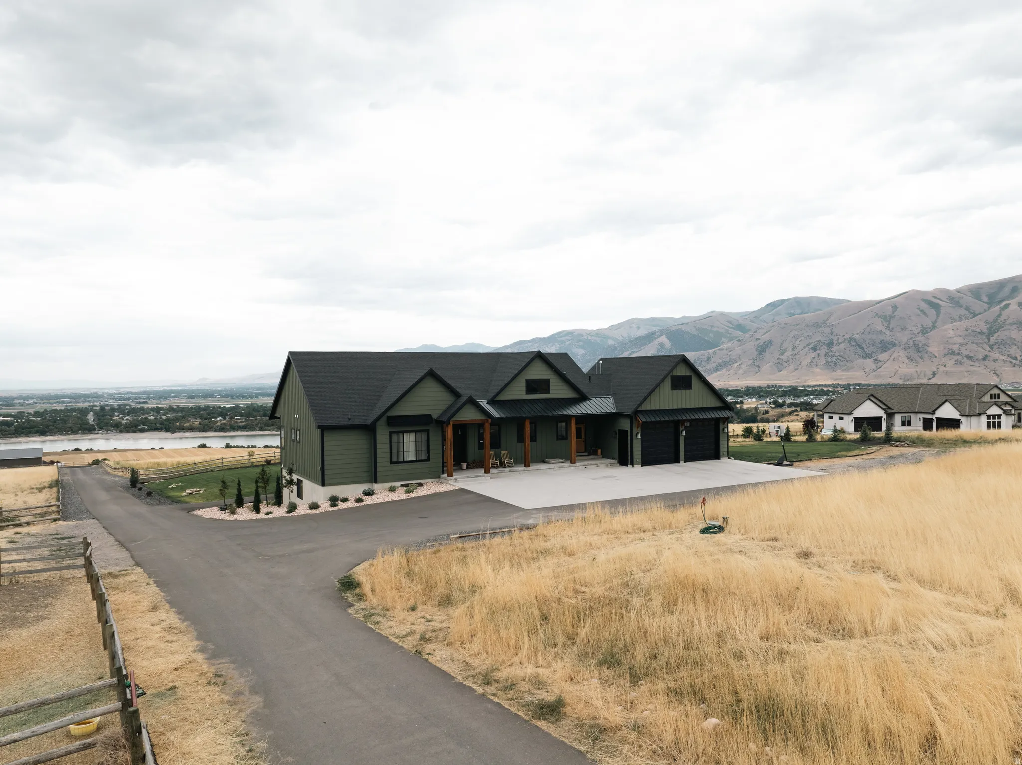 Modern farmhouse architecture with dark green siding and black trim accents
