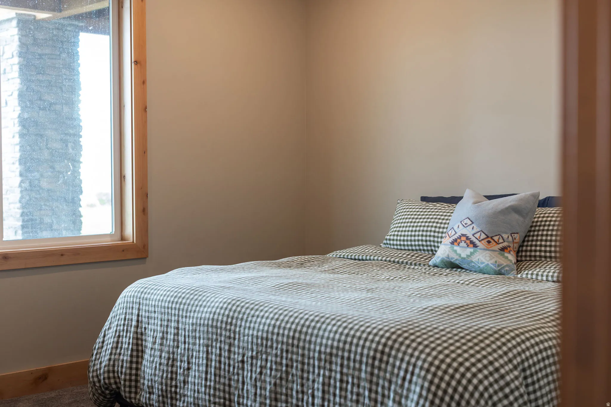 Neutral wall paint, wood window trim, and carpeted flooring