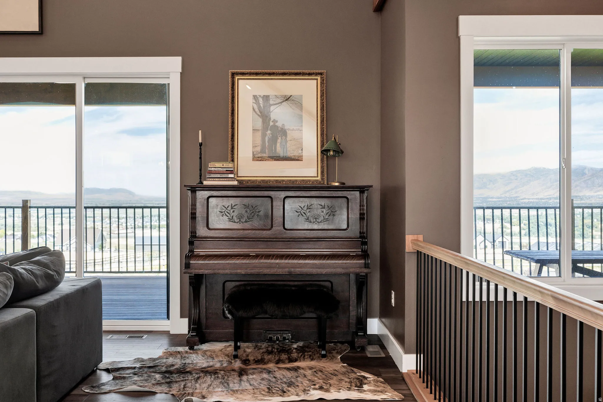 Sliding glass doors, dark wood-finish flooring, a dark wood staircase with black balusters, and a light-toned wood handrail
