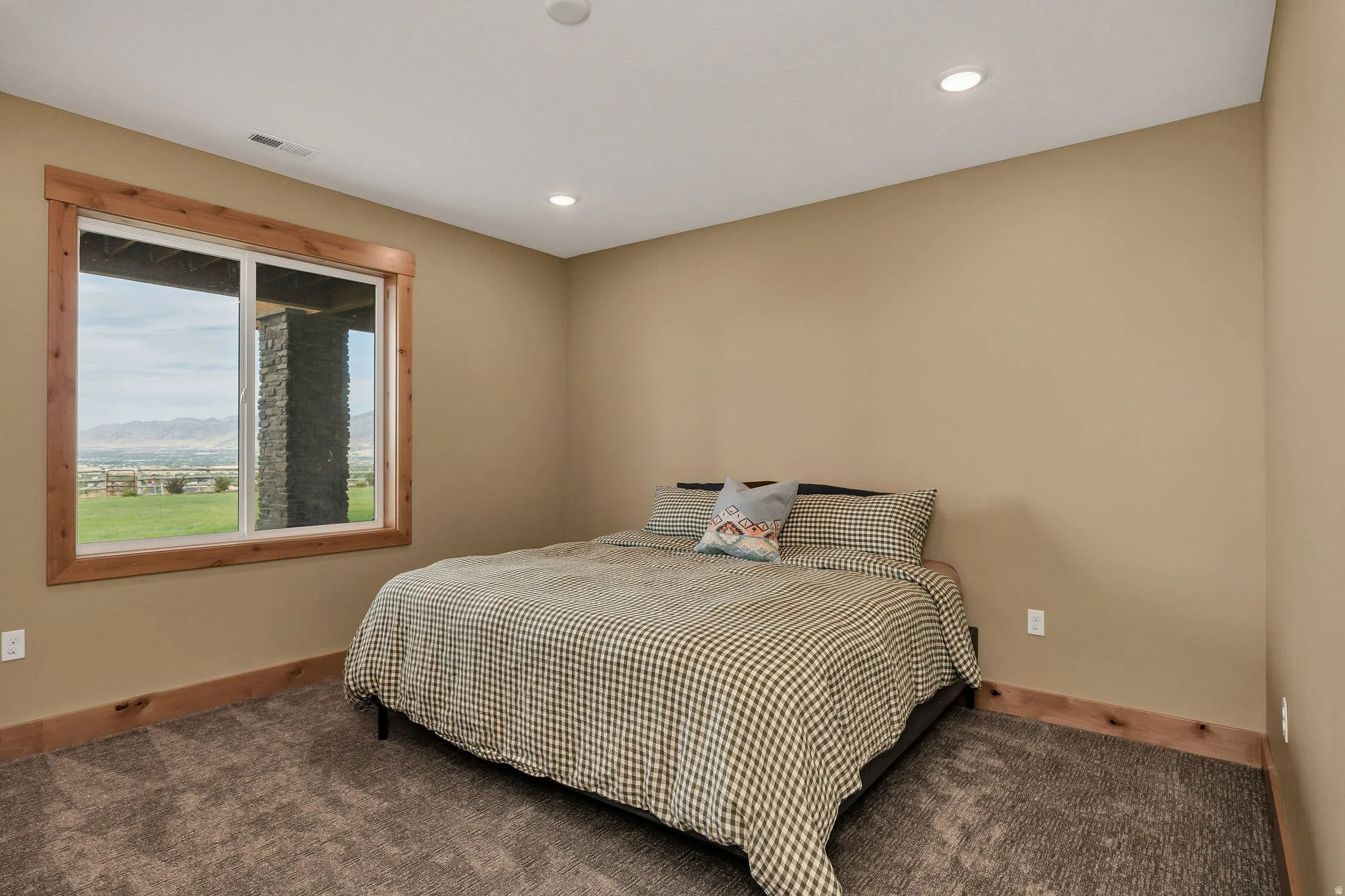Recessed ceiling lighting, wood-trimmed window, window with exterior stone column, neutral wall color, and carpet flooring