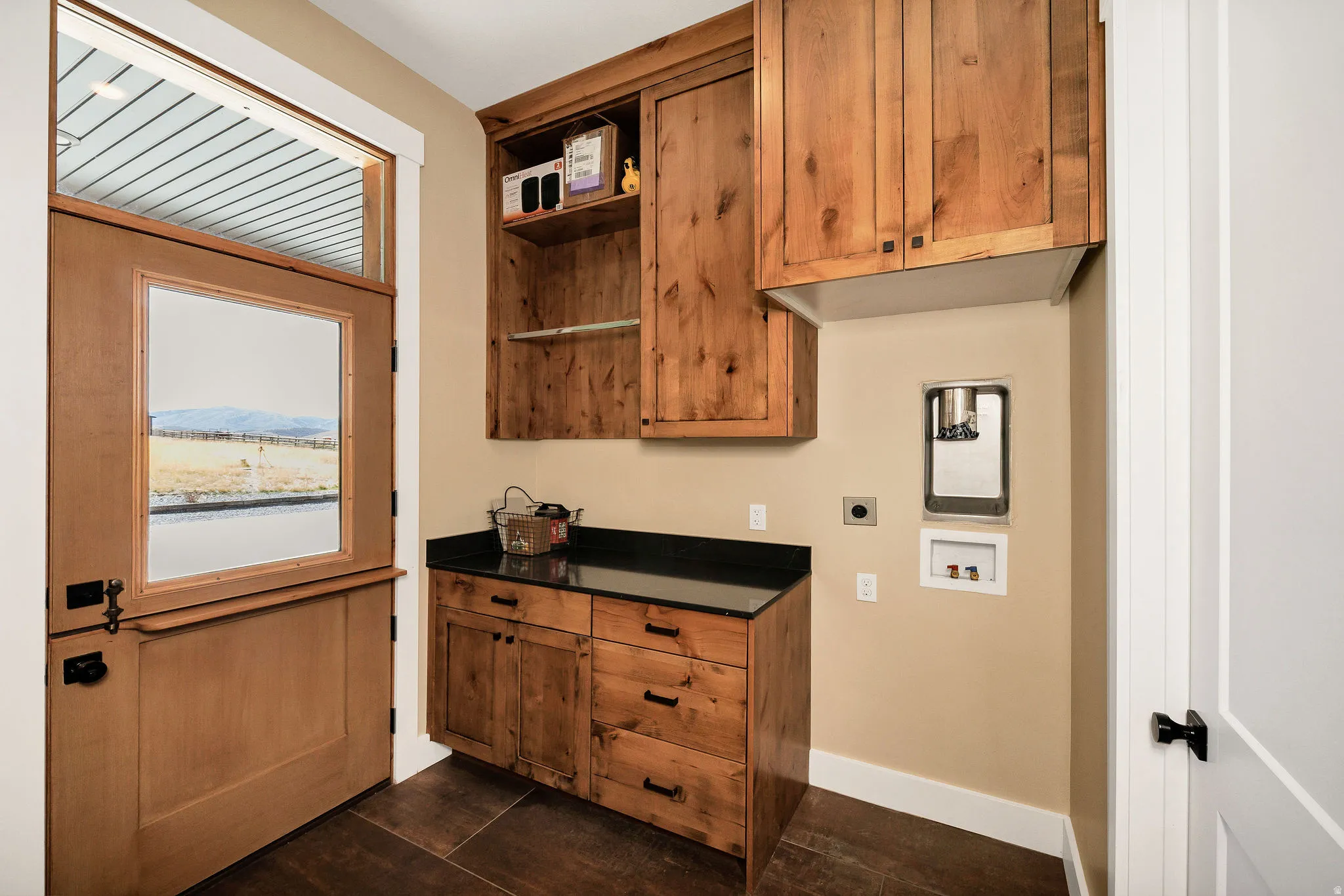 Wood-finish flooring, custom wood cabinetry, dark countertop, and a Dutch door with transom window
