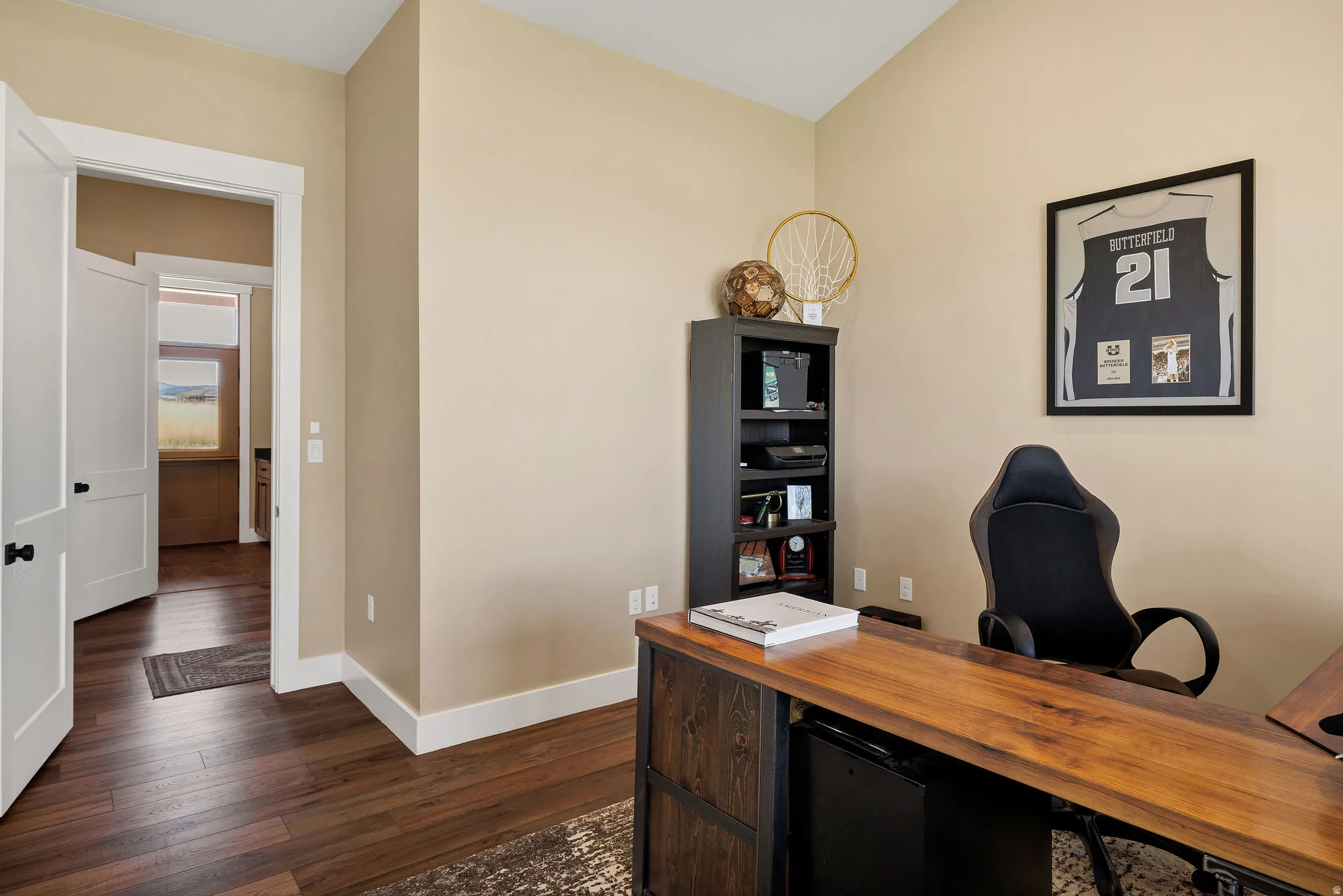 Vaulted ceilings with wood-finish flooring, white trim, and a solid core door