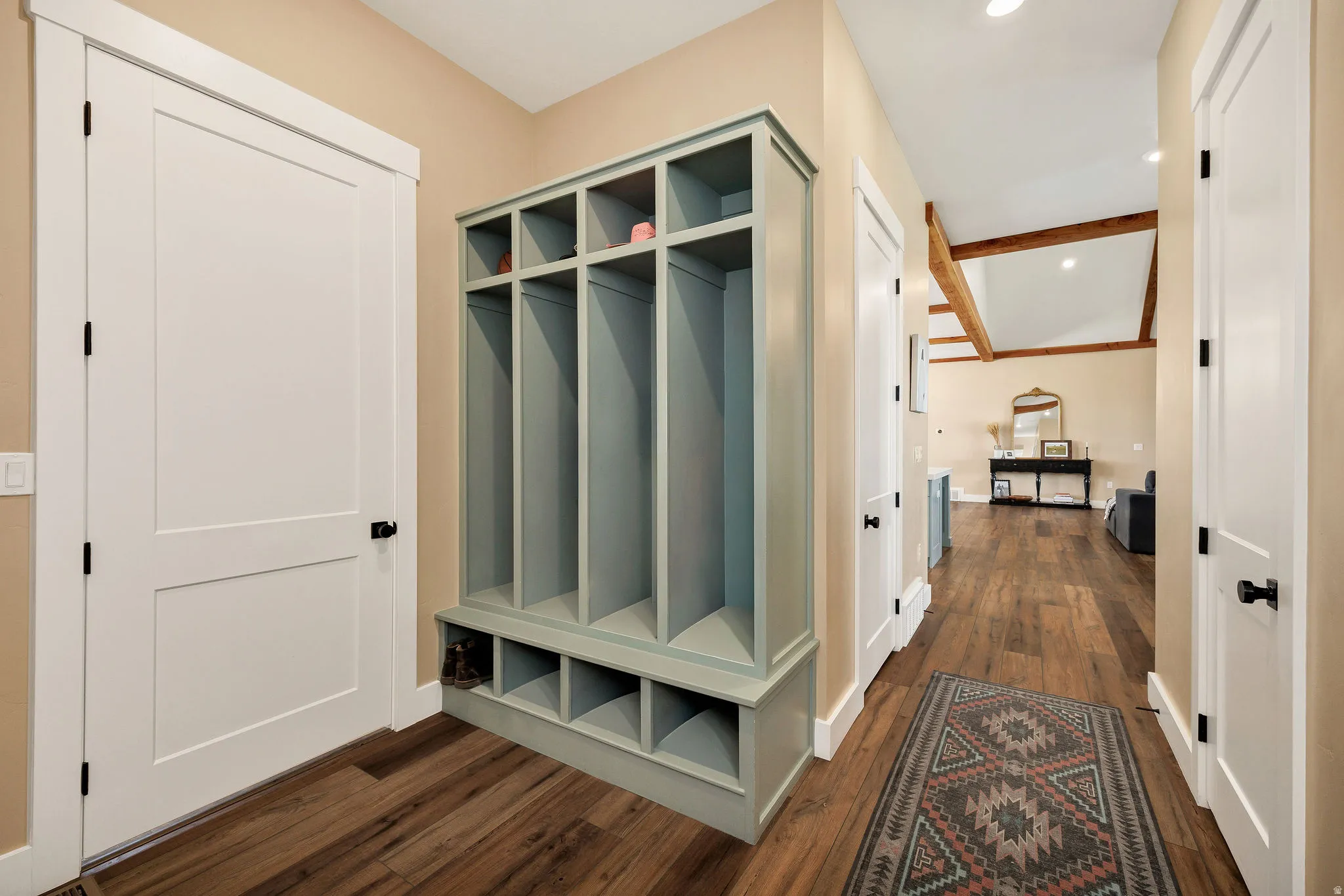 Built-in storage cubbies, wood-finish flooring, exposed ceiling beams, and recessed lighting