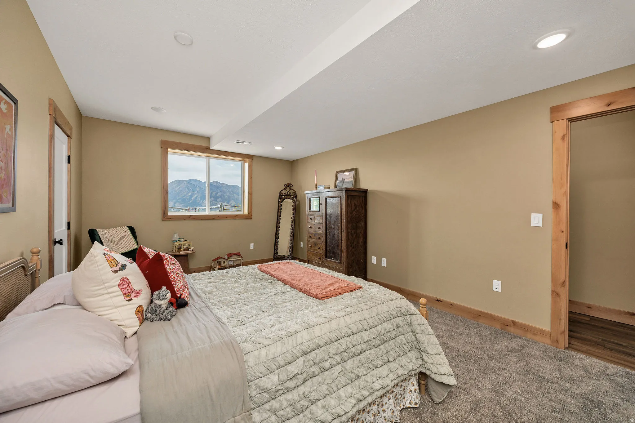 Recessed lighting with a flat ceiling, wood-trimmed window, and wood-finish door frames