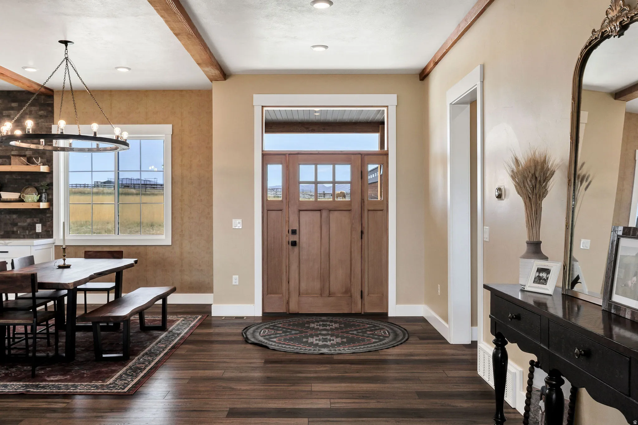 Wood-finish flooring throughout, featuring a natural wood-panel entry door with transom and sidelight windows