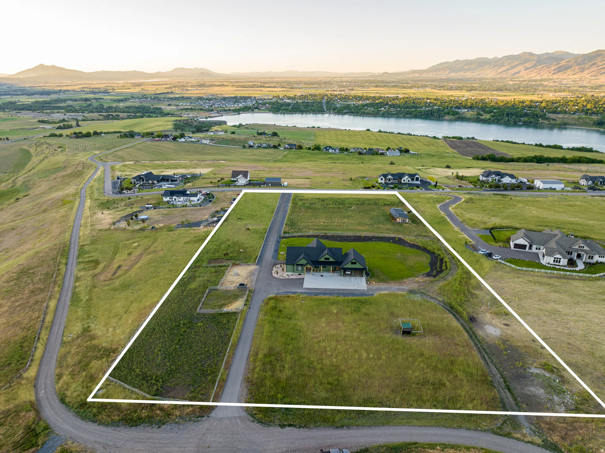 Expansive property featuring a single-family residence, surrounding green space, and a distant body of water