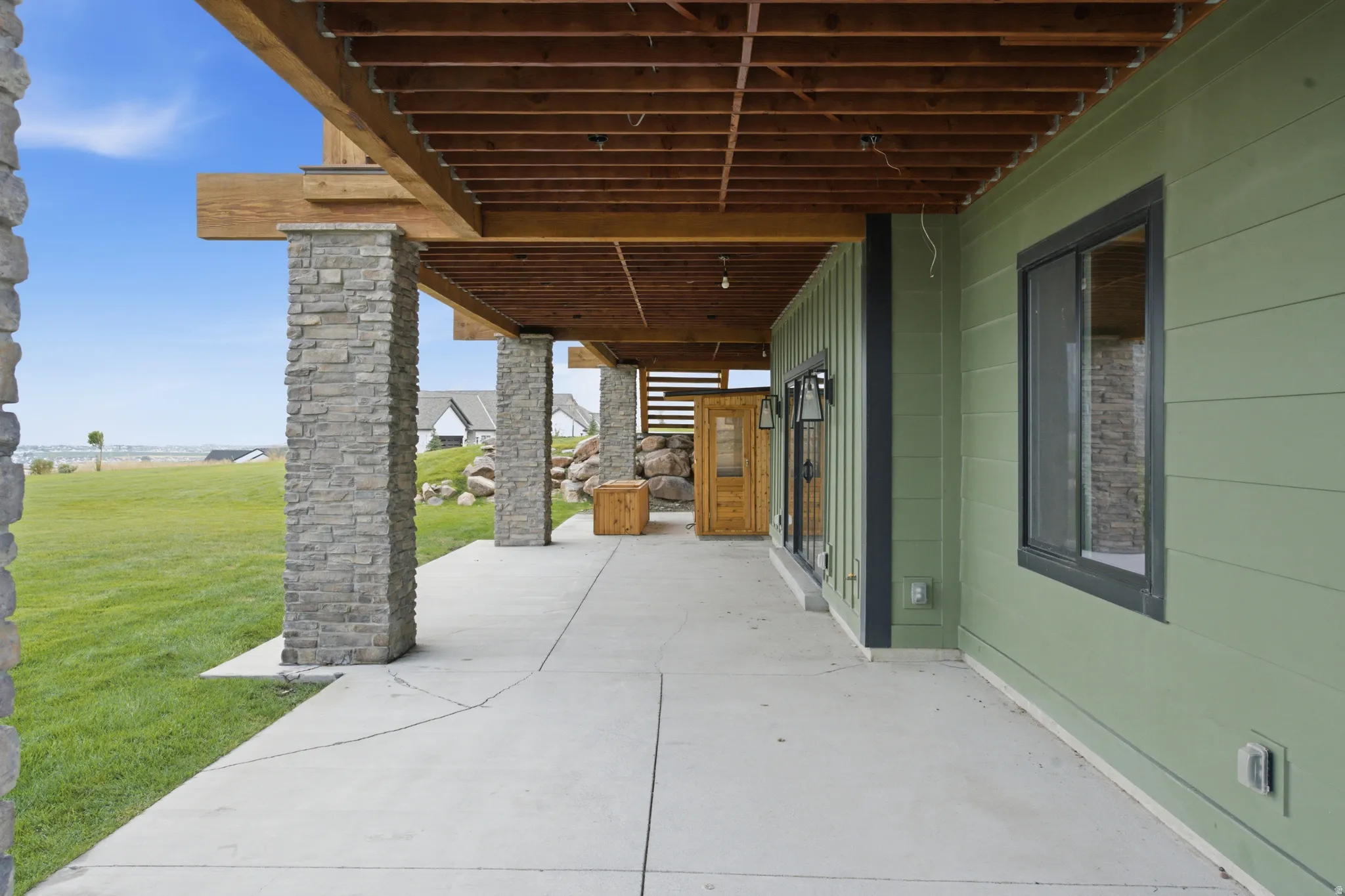 Covered concrete patio with stone-wrapped columns