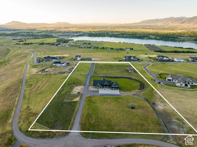 Expansive property featuring a single-family residence, surrounding green space, and a distant body of water