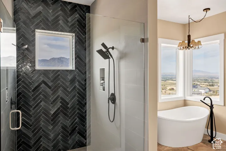 Glass-enclosed shower with black herringbone tile, dual shower heads, and built-in niche