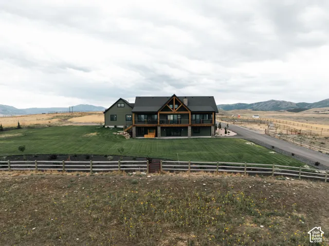Modern farmhouse residence showcasing a striking dark exterior with mixed material detailing, expansive multi-level design with prominent gabled rooflines, and manicured grounds anchored by white ranch-style fencing