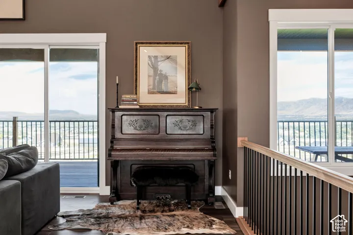 Sliding glass doors, dark wood-finish flooring, a dark wood staircase with black balusters, and a light-toned wood handrail