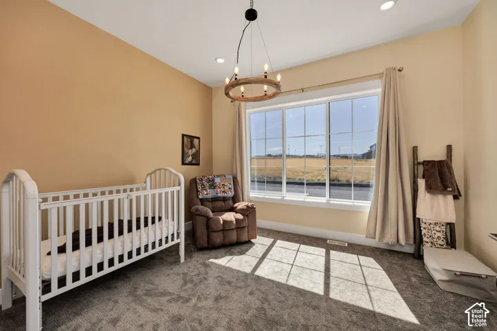 Recessed lighting, large multi-pane window, wood-finish chandelier, and neutral-toned walls