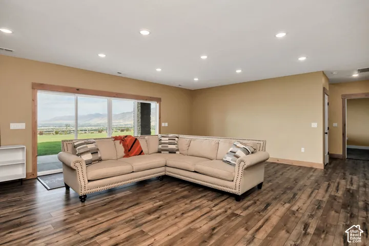 Expansive room featuring wood-finish flooring, recessed lighting, and a sliding glass door with wood trim