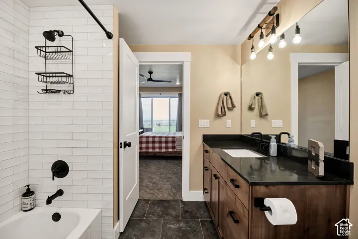 Bathroom featuring a single vanity with a dark countertop, white undermount sink, and wood-finish cabinetry