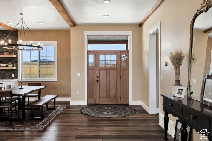 Wood-finish flooring throughout, featuring a natural wood-panel entry door with transom and sidelight windows