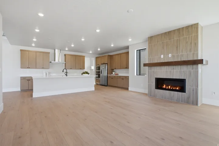 Modern kitchen with light wood-finish cabinetry, a large kitchen island, stainless steel appliances