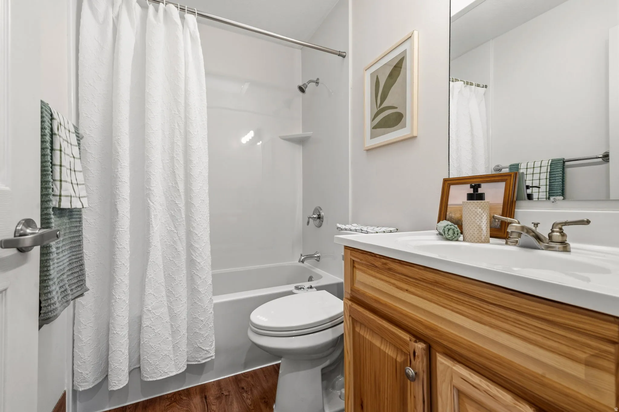 Full vanity with single basin sink, wood-finish cabinetry, and brushed nickel faucet