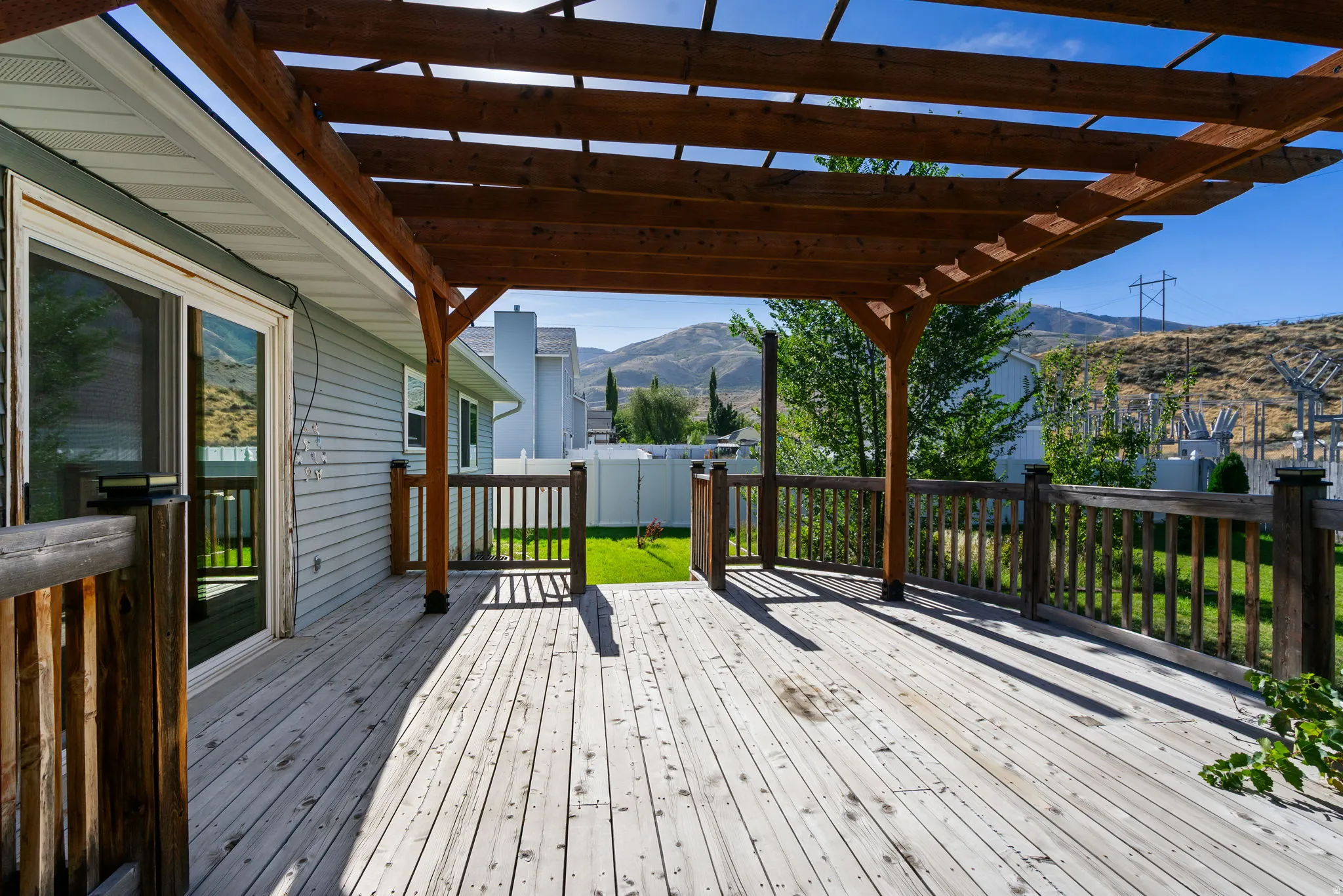 Expansive wood deck with a built-in wood pergola and wood railings