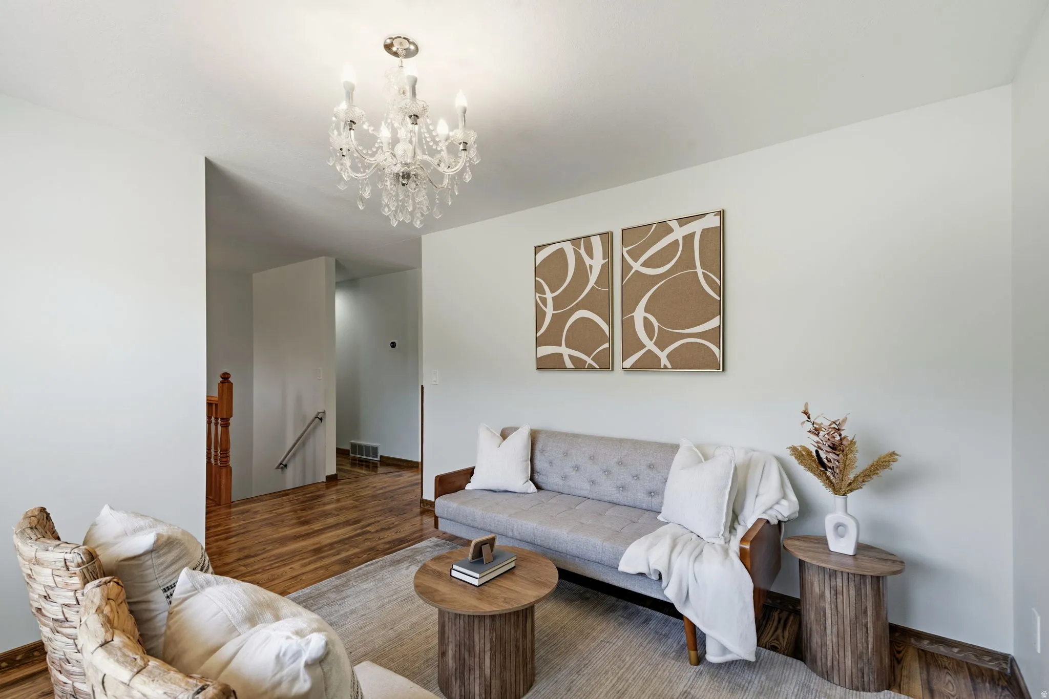 Chandelier lighting, wood-finish flooring, and light-toned walls