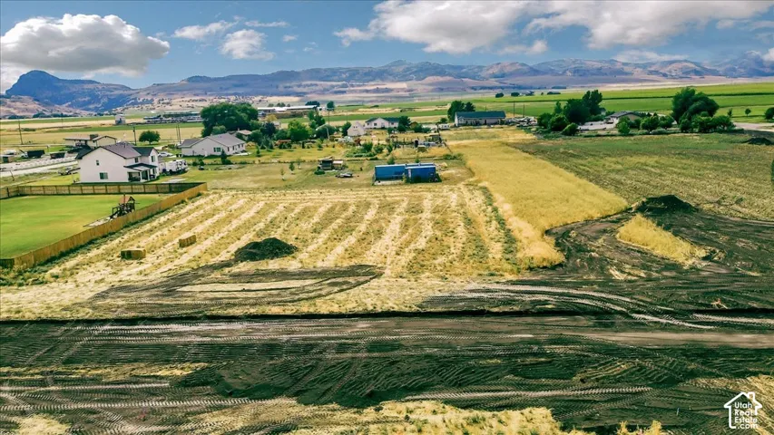 Expansive land parcel with surrounding agricultural fields and distant mountain scenery