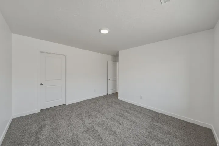 Recessed lighting, plush carpeting, white walls, and white trim