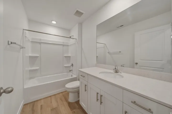 White vanity with brushed nickel hardware, integrated sink, and stone-finish countertop