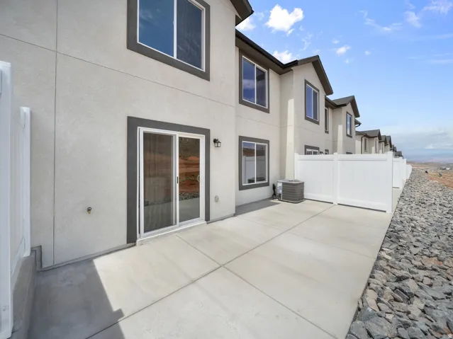 Concrete patio featuring a sliding glass door and exterior lighting
