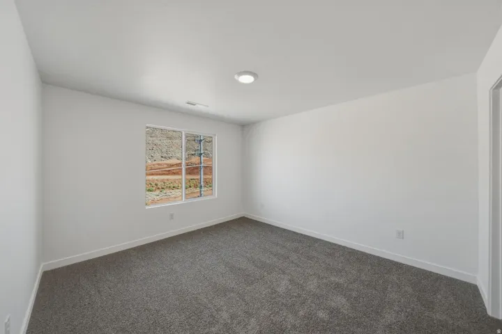 Recessed lighting, neutral wall tones, gray carpeting, a window with a mountain backdrop, and white trim