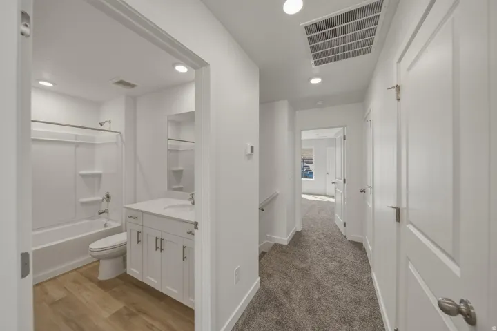 Bathroom featuring a white vanity with a white countertop and a tub/shower combination