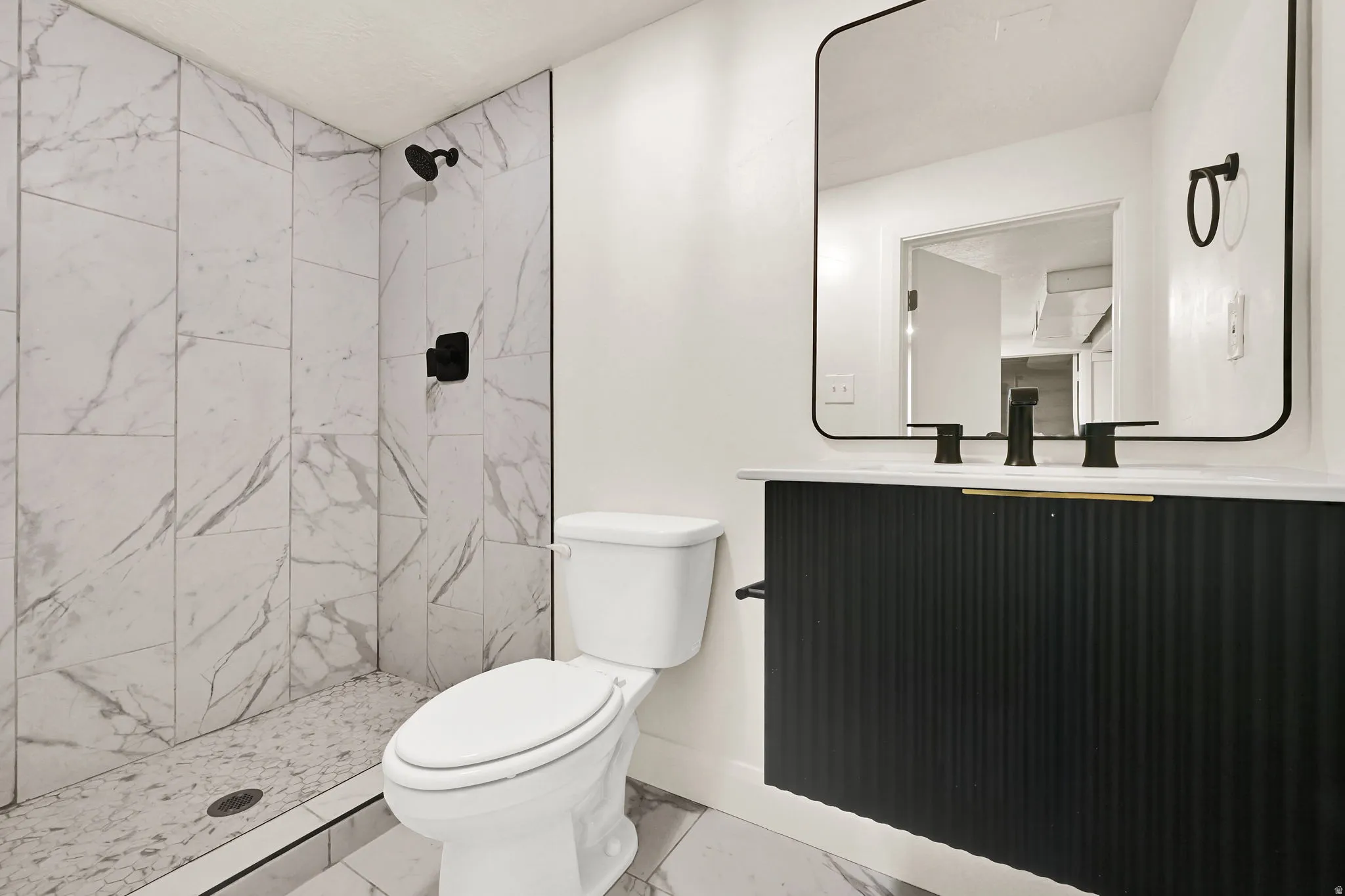 Wall-mounted vanity with a fluted facade, black faucet, and white countertop