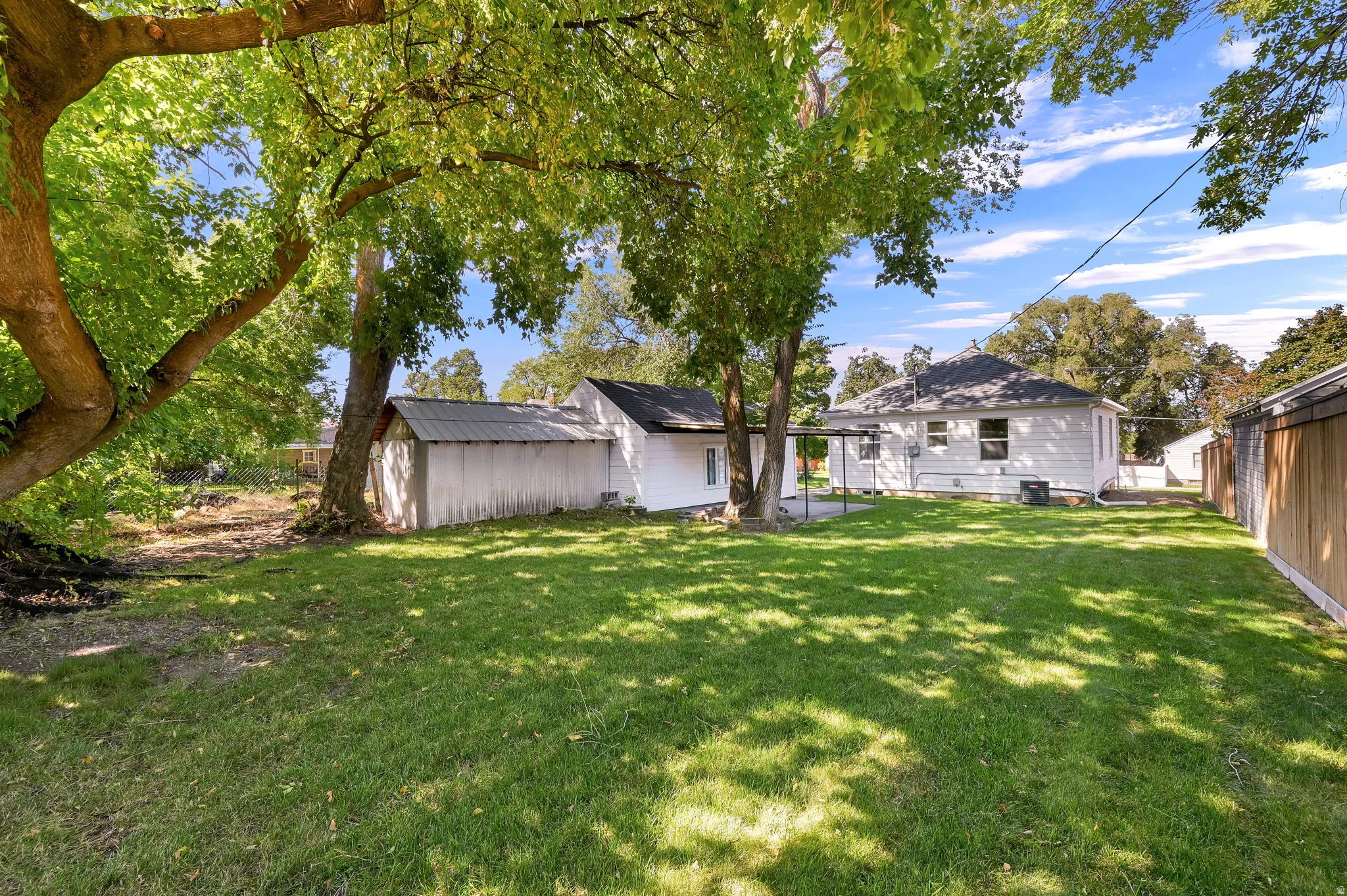 Expansive lawn area with mature trees providing coverage
