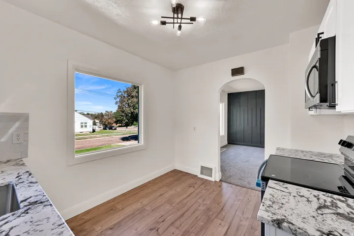 Wood-finish flooring, white walls, and a contemporary ceiling light fixture