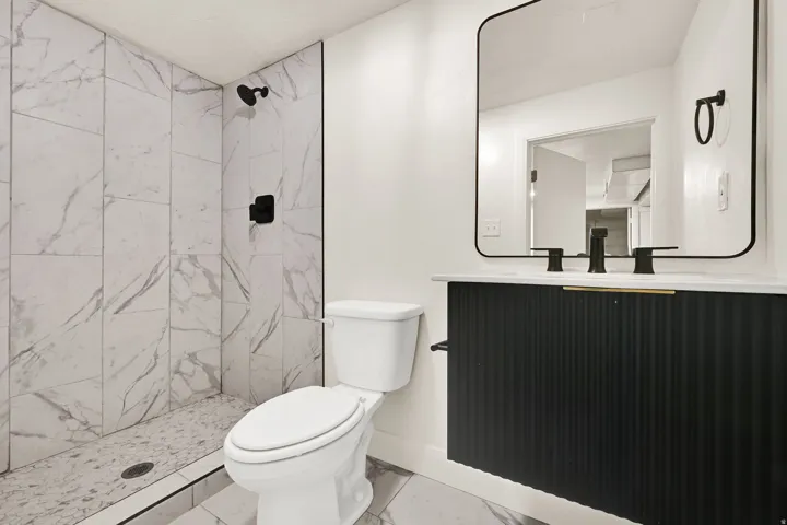 Wall-mounted vanity with a fluted facade, black faucet, and white countertop