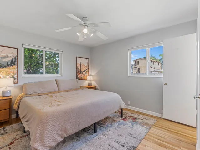 Primary bedroom with hardwood floors and natural light.