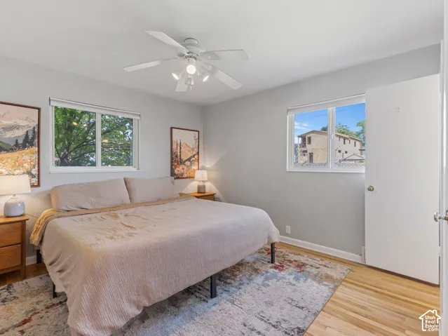 Primary bedroom with hardwood floors and natural light.