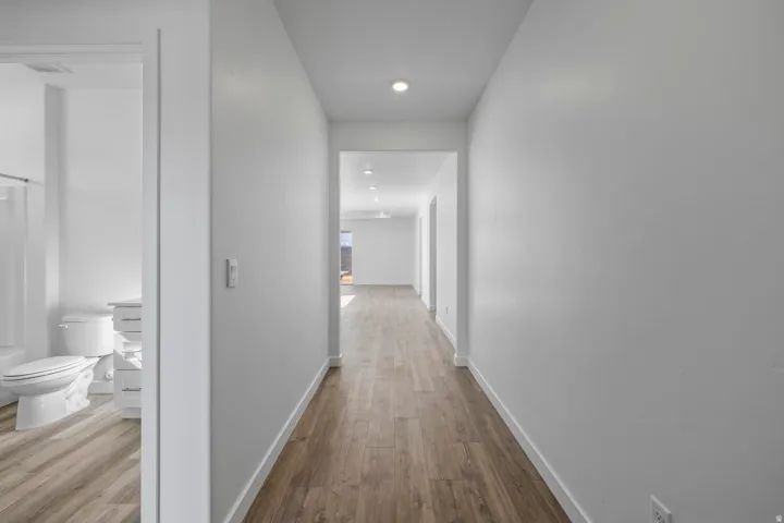 Hallway with wood-finish flooring and recessed lighting