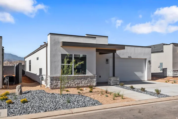 Modern stucco exterior with stone accents, covered entry, and attached garage