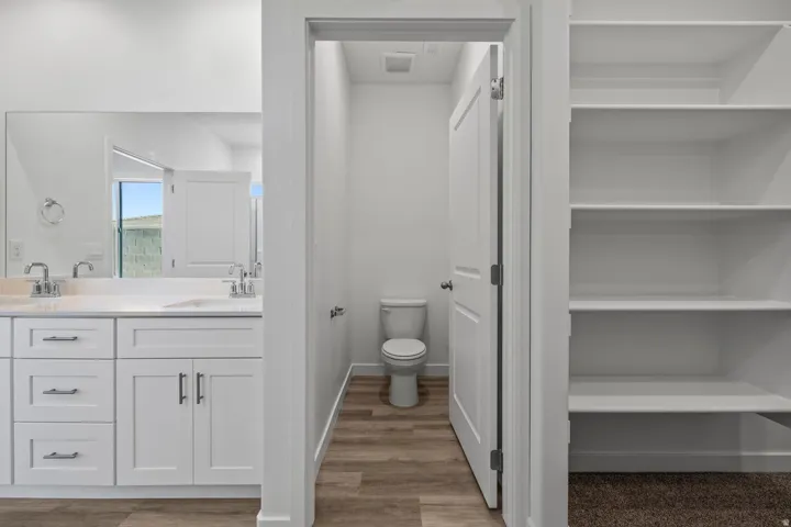Dual vanity with white cabinetry, polished chrome fixtures, and a large mirror